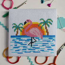Load image into Gallery viewer, Close-up of a finished flamingo beach cross stitch with palm trees, sunset and blue waves