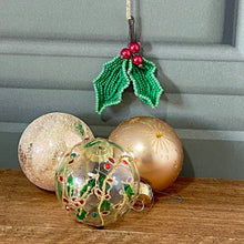 Load image into Gallery viewer, Handmade beaded holly leaves with red berries hanging beside glass Christmas baubles