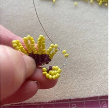 Load image into Gallery viewer, Hand holding yellow beaded pansy petals being made with wire from the Pansy Beaded Flower Craft Kit