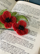 Load image into Gallery viewer, Close-up of a beaded poppy showing red petals and black centre.