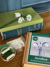 Load image into Gallery viewer, Contents of the snowdrop beaded flower kit: white and green seed beads, wire, floristry tape and instructions.