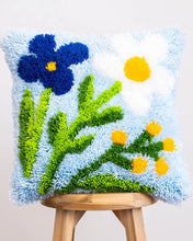 Load image into Gallery viewer, Contents of the Baby Blue Wild Blooms latch hook cushion kit: wooden hook, printed canvas and pre-cut yarn.

