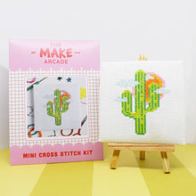 Load image into Gallery viewer, Cactus mini cross stitch kit in its pink Make Arcade envelope next to the finished stitching displayed on a mini easel
