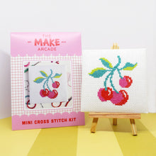 Load image into Gallery viewer, Cherries mini cross stitch kit in its pink Make Arcade envelope next to the finished stitching on a mini easel
