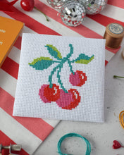 Load image into Gallery viewer, Finished cherries mini cross stitch kit design stitched on white Aida fabric on a red and white striped background
