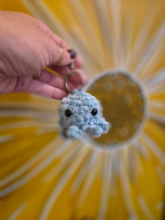 Blue crochet octopus keyring held in a hand, by Gobblin Glass