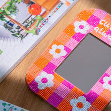 Load image into Gallery viewer, Close-up of sparkly diamond painting gems on a pink and orange gingham mirror frame with white flowers
