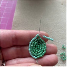 Load image into Gallery viewer, Hand holding a green beaded succulent leaf made with the Echeveria beaded craft kit
