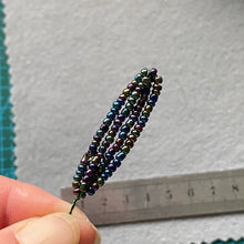 Load image into Gallery viewer, Close-up of an iridescent beaded dragonfly showing metallic teal glass beads.
