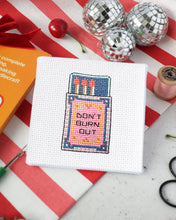 Load image into Gallery viewer, Finished matchbox mini cross stitch design reading Don't Burn Out, stitched on white Aida fabric with a red and white striped background
